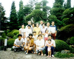 実家の庭にて親族と記念写真　広木さんは下段の左から一人目